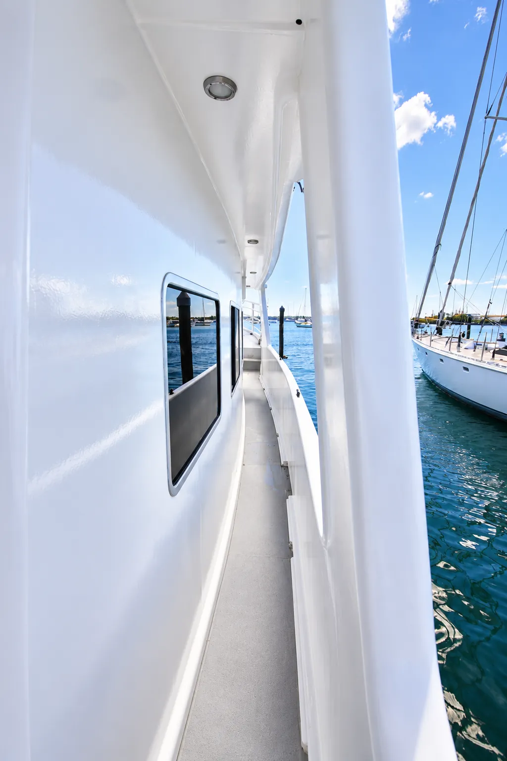 Covered side walkway along Kiwa II with harbour views and yachts moored alongside